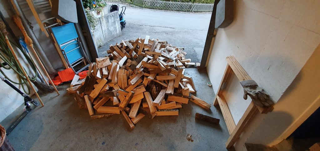 Ein Haufen Holz vor und in der Garage